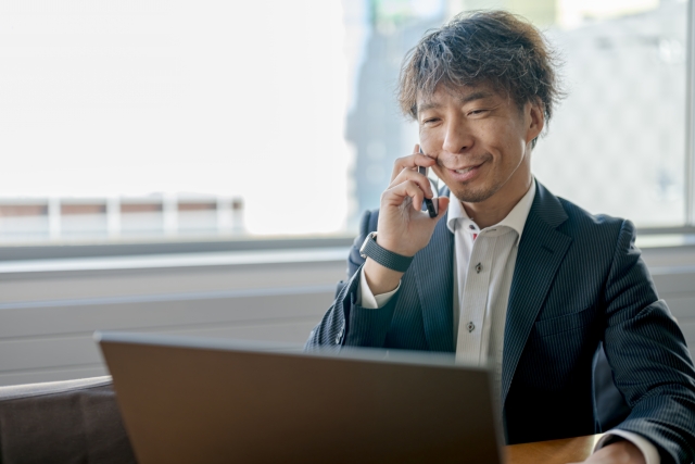 用地仕入れ 営業 コツ 電話しながらPCを使う男性